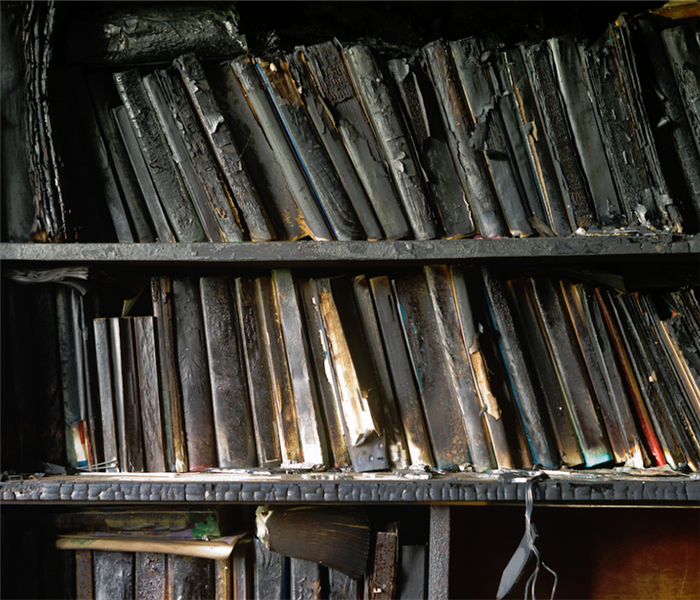 a fire damaged bookshelf covered with soot