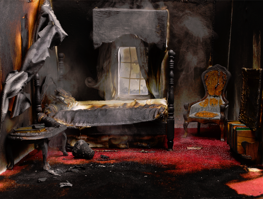 a fire damaged bedroom with soot covering everything