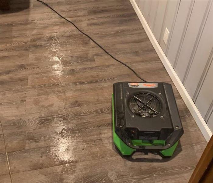 SERVPRO equipment in a room that has water on the floor. 